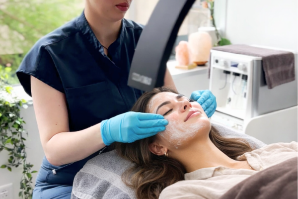 Patient receiving a DiamondGlow facial treatment with exfoliation mask applied in a dermatology office