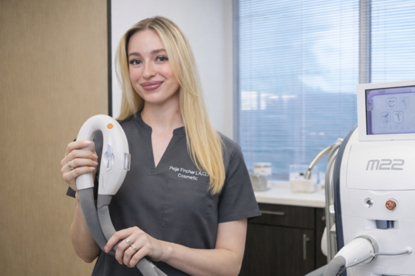 Aesthetic provider holding M22 handpiece for photofractional skin treatment in Austin