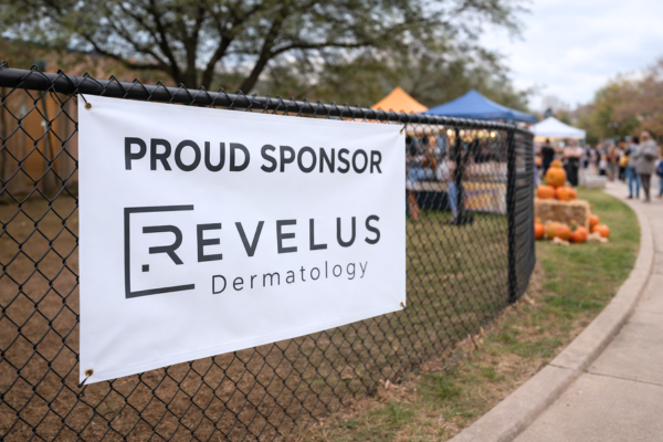 Revelus Dermatology sponsorship banner displayed at a local Austin school community event
