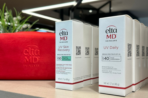 EltaMD sunscreen products displayed with a summer tote at Revelus Dermatology.